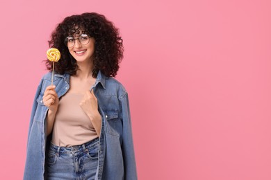 Photo of Beautiful woman with lollipop on pink background, space for text