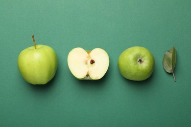 Photo of Whole, cut green apples and leaf on color background, flat lay