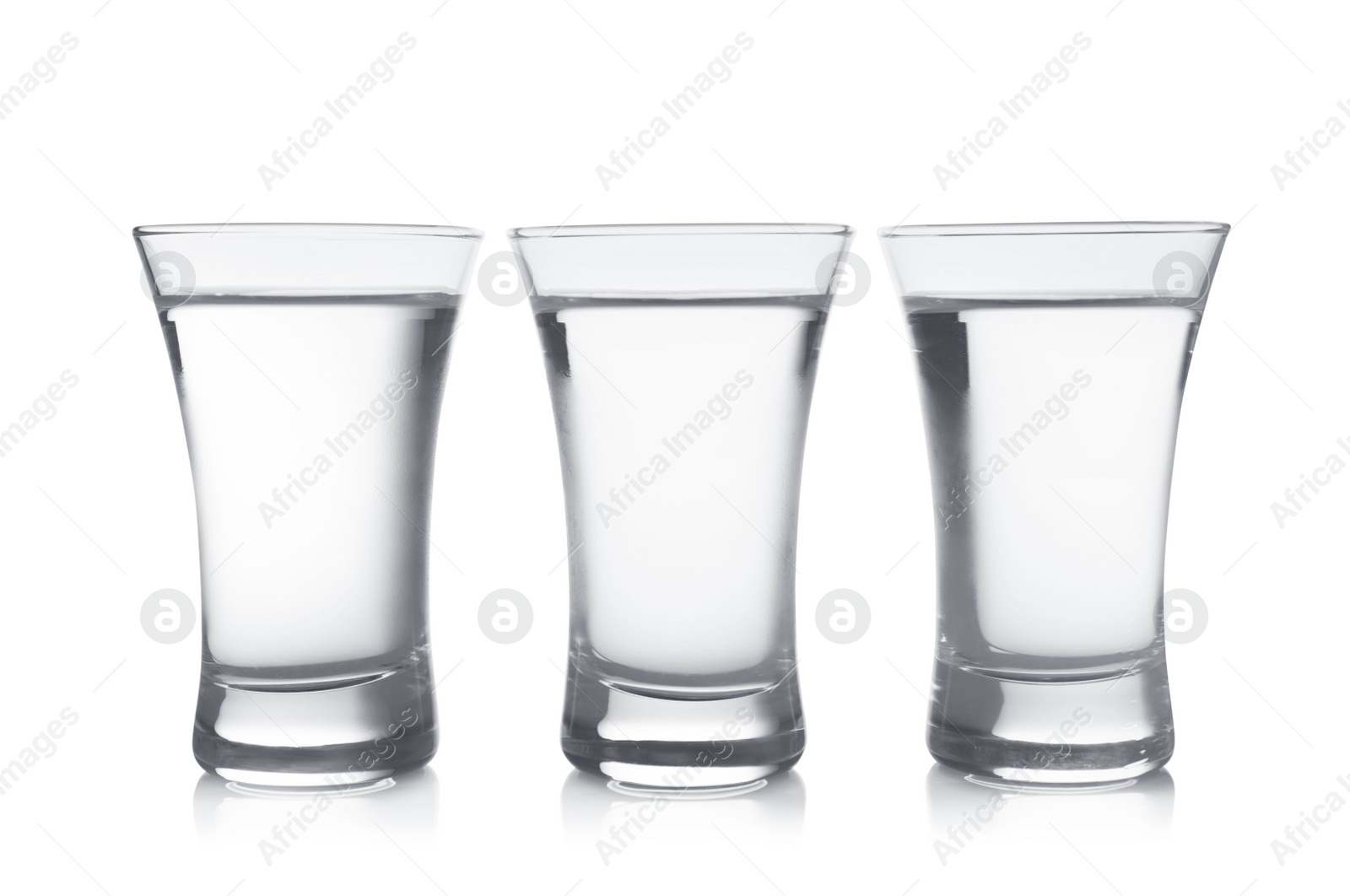 Photo of Cold vodka in shot glasses on white background