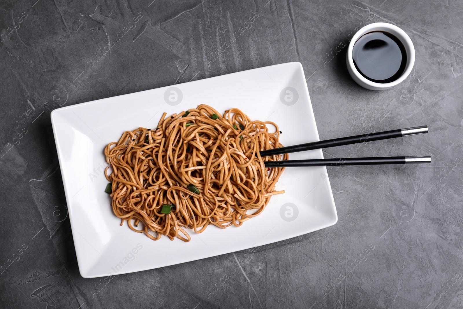 Photo of Cooked noodles served on grey table, flat lay