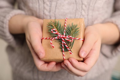 Photo of Little child holding decorated box, closeup. Christmas gift