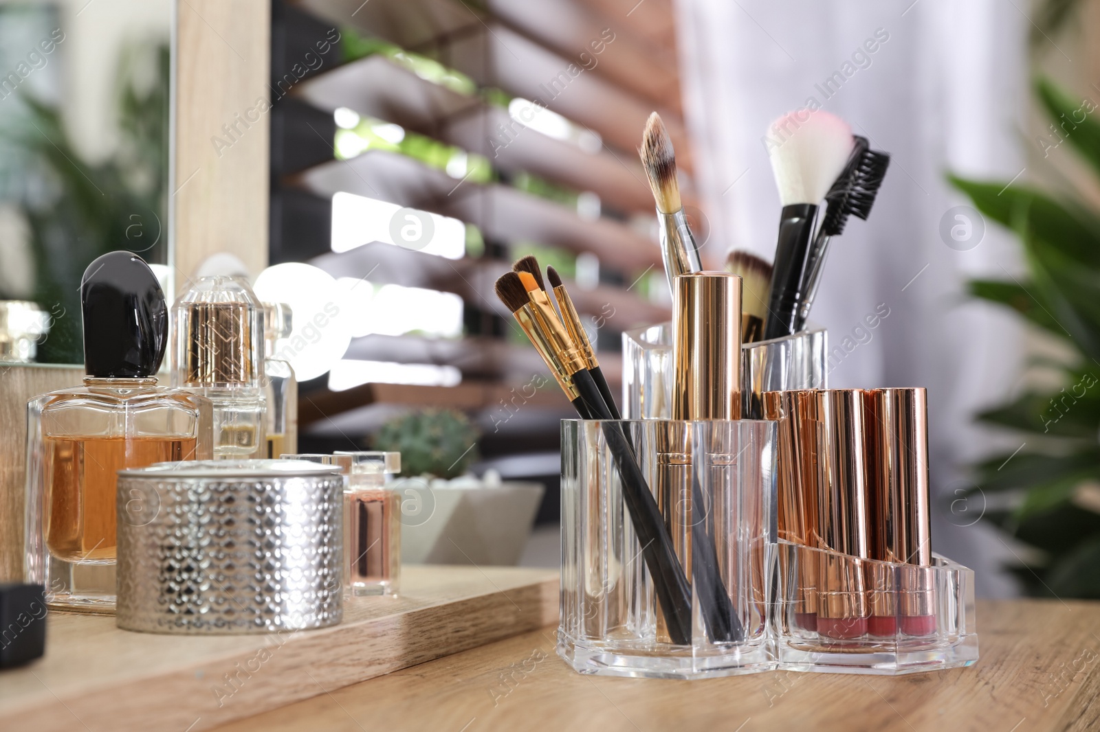 Photo of Makeup products and accessories on dressing table against blurred background