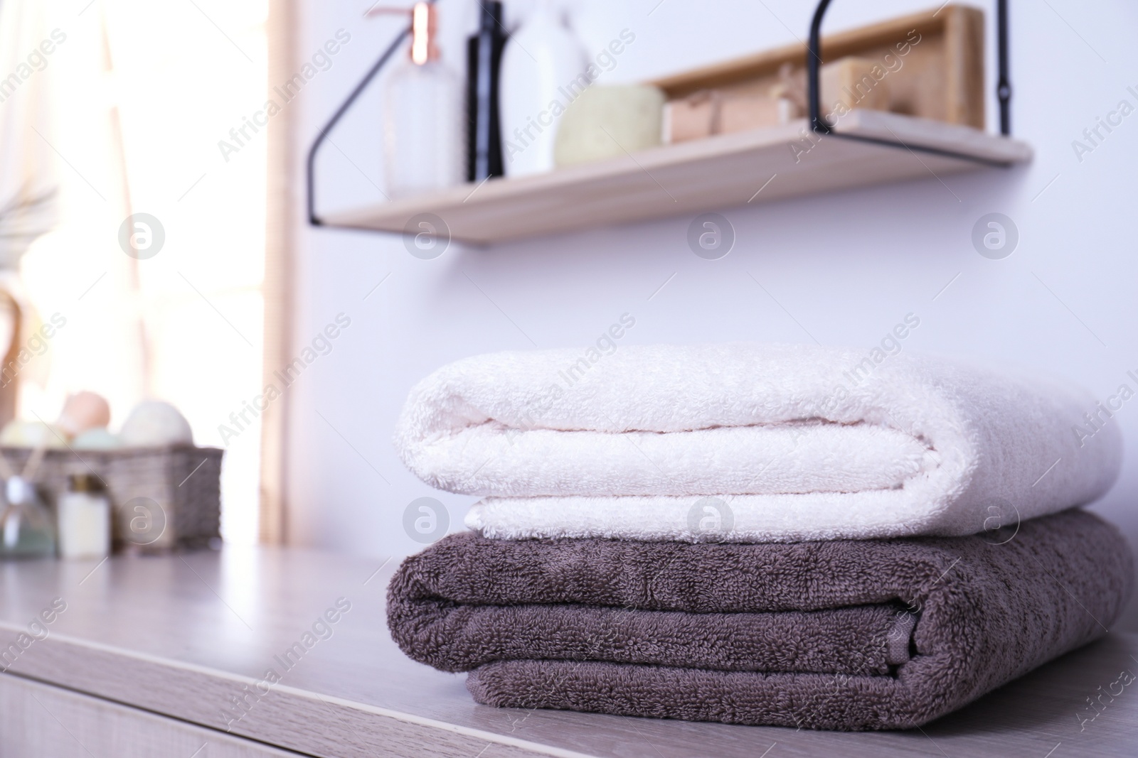 Photo of Stack of fresh towels on table in bathroom. Space for text