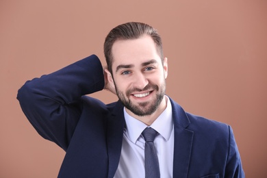 Portrait of young businessman with beautiful hair on color background