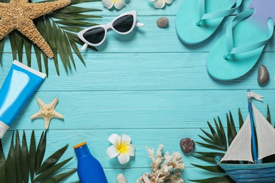 Flat lay composition with stylish beach accessories on light blue wooden background, space for text