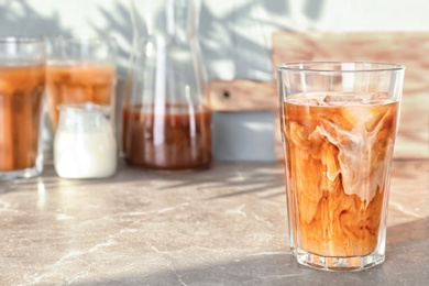 Glass with cold brew coffee and milk on table