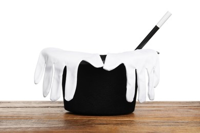 Photo of Magician's hat, gloves and wand on wooden table against white background