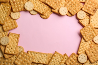 Photo of Frame of delicious crackers on pink background, flat lay. Space for text