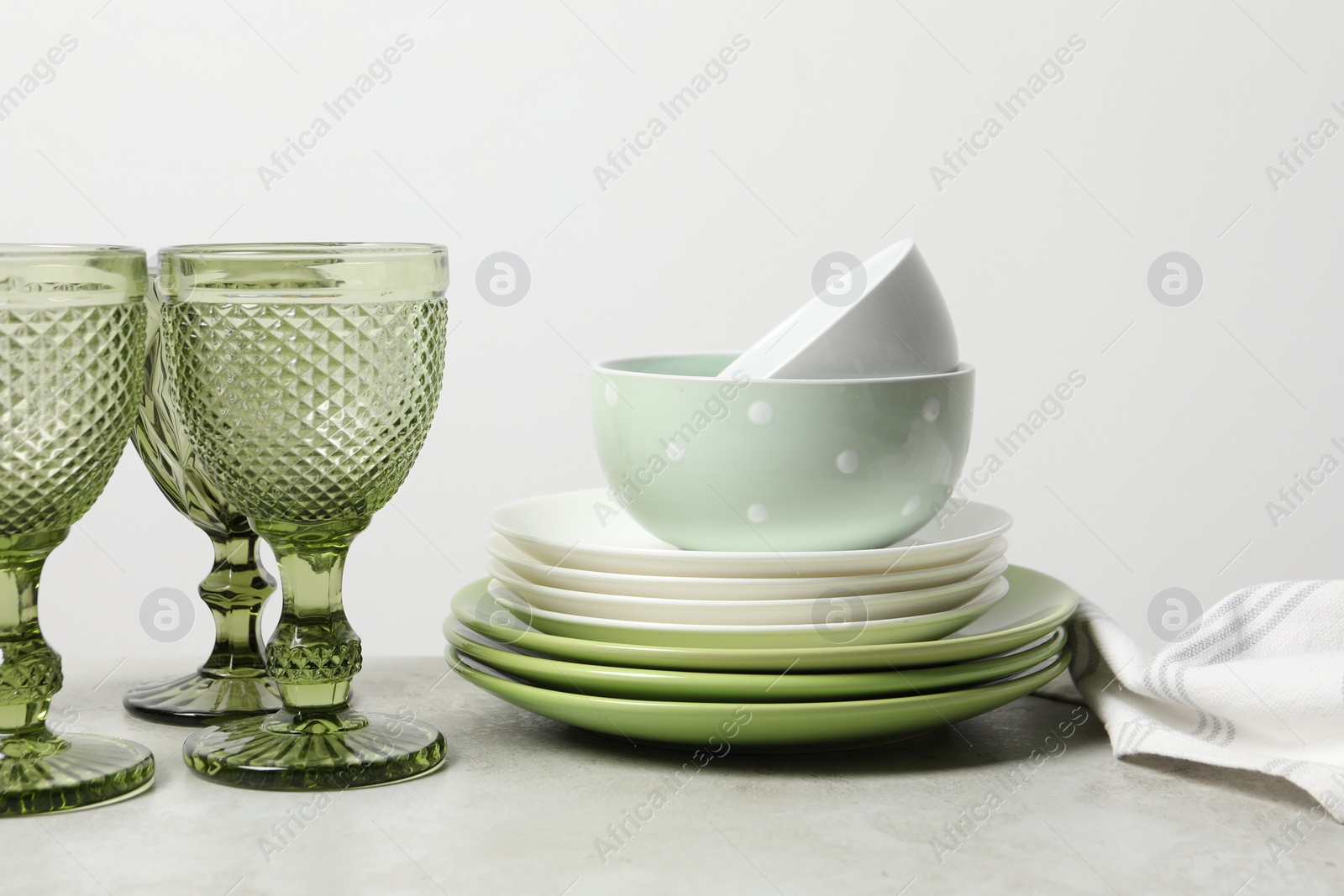 Photo of Beautiful ceramic dishware and glasses on light grey table