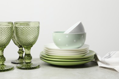 Beautiful ceramic dishware and glasses on light grey table