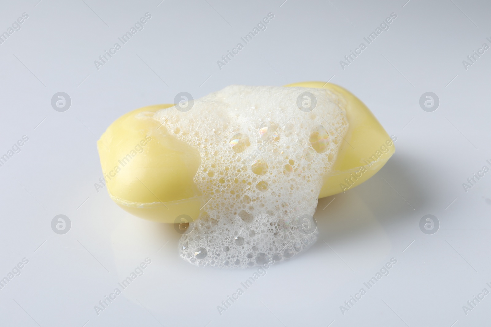 Photo of Soap with fluffy foam on white background