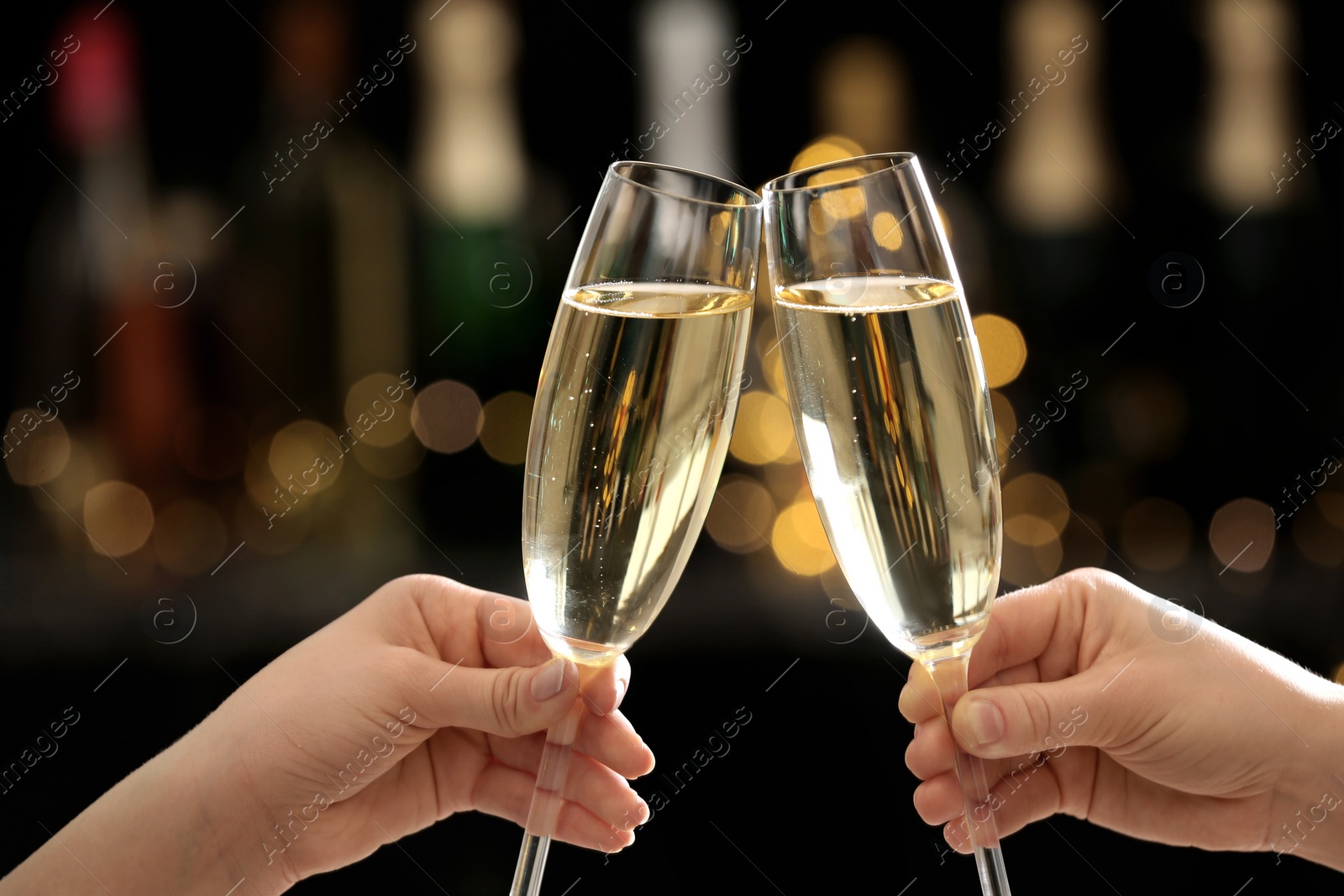 Photo of People clinking glasses of champagne on blurred background, closeup