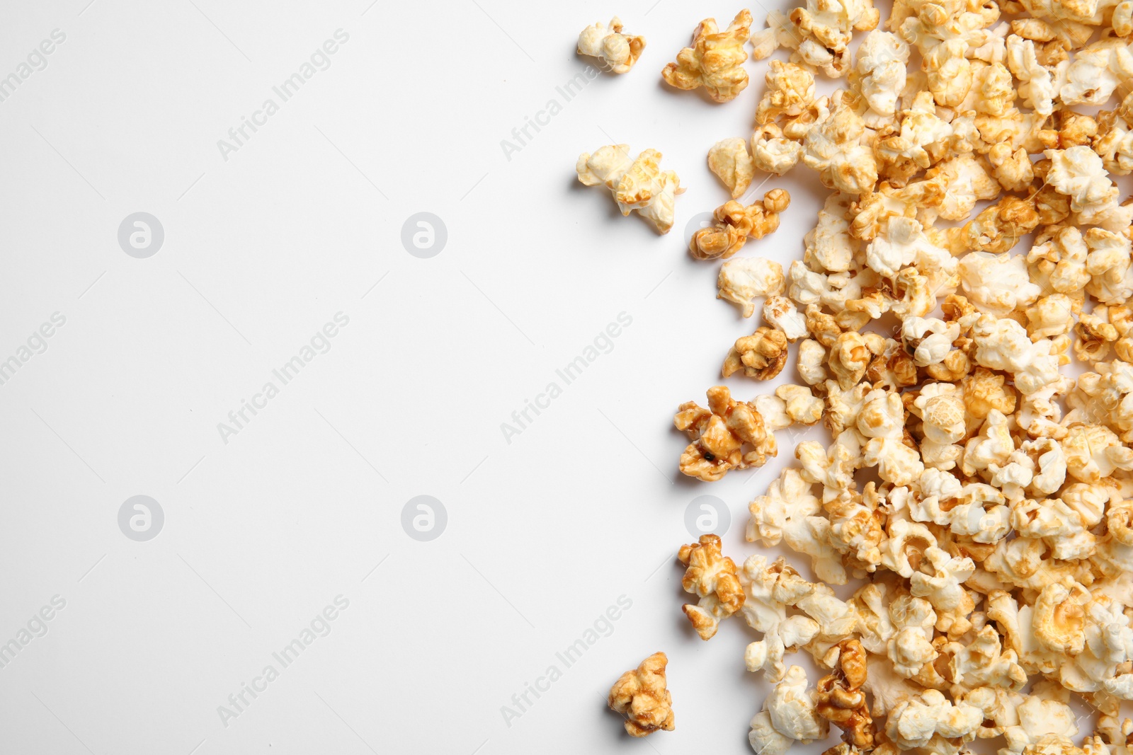 Photo of Delicious caramel popcorn on white background, top view