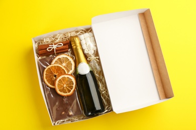 Photo of Stylish gift set on yellow background, top view