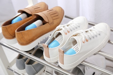 Photo of Shoes with capsule fresheners on rack in room