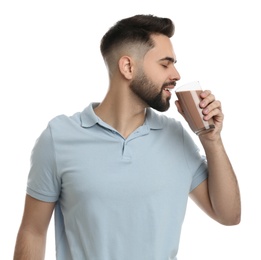 Photo of Young man drinking chocolate milk on white background
