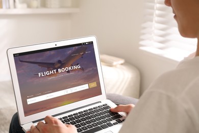 Image of Man using laptop to book flight at home, closeup