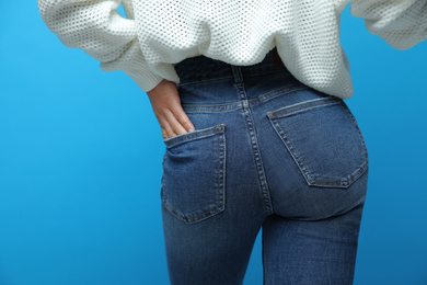 Photo of Woman wearing jeans on blue background, closeup