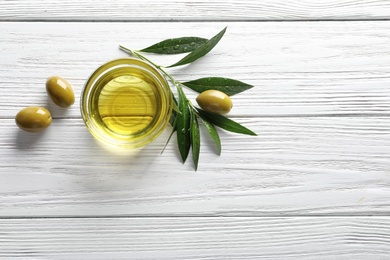 Flat lay composition with fresh olive oil on wooden background