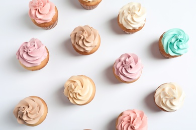 Flat lay composition with delicious birthday cupcakes on white background