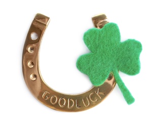 Photo of Golden horseshoe and decorative clover leaf on white background, top view. Saint Patrick's Day celebration