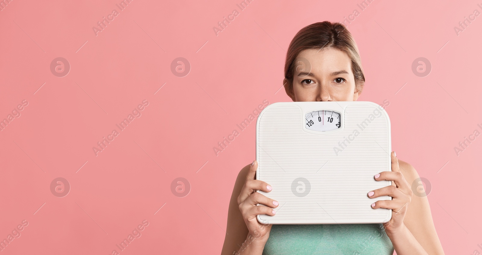 Photo of Woman in sportswear with scales on pink background. Space for text