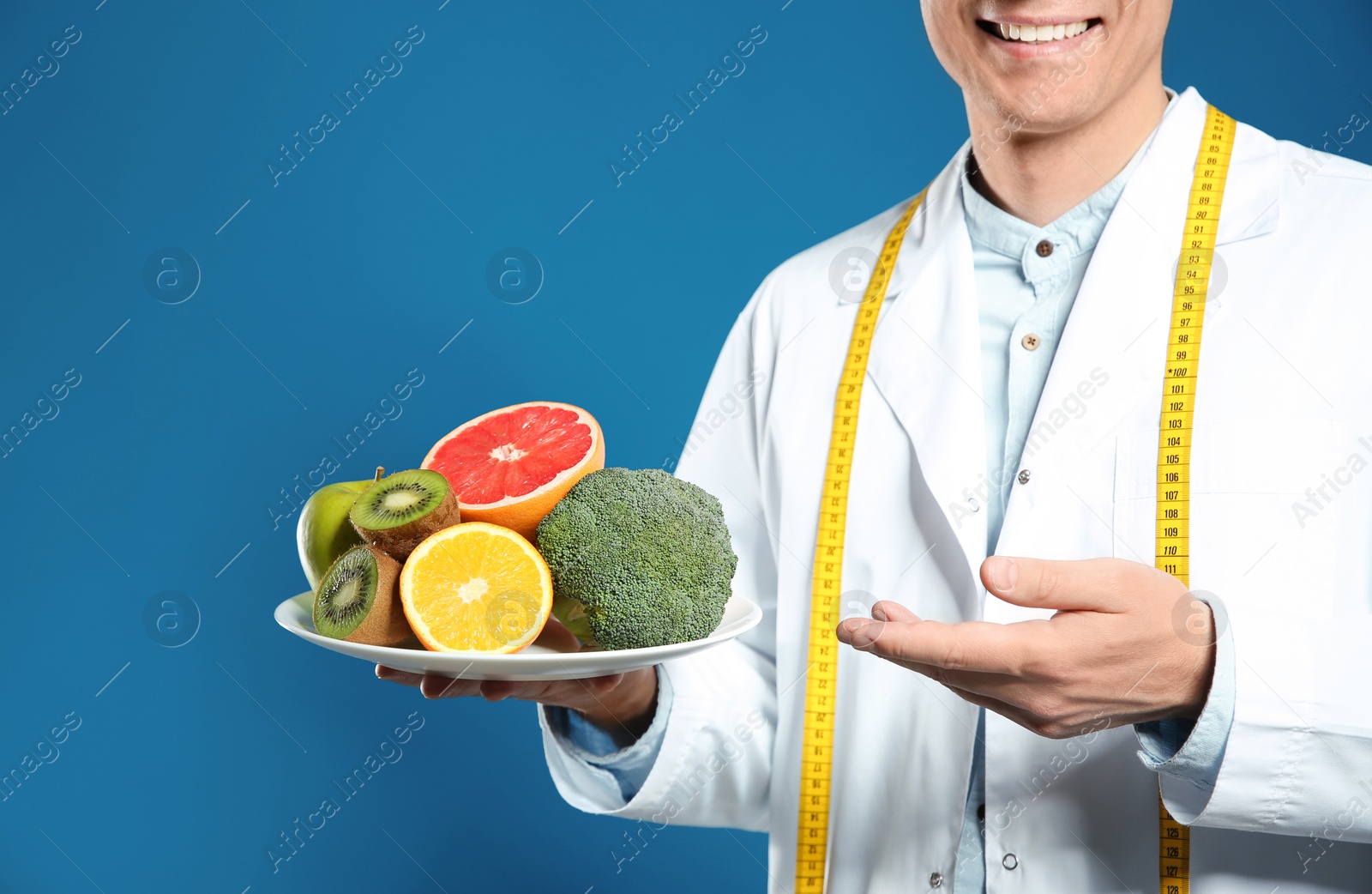 Photo of Nutritionist with healthy products on blue background, closeup