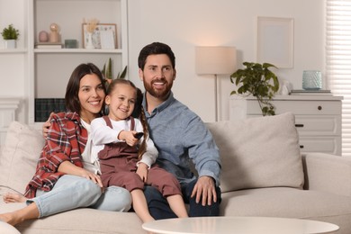 Photo of Happy family watching TV on sofa at home, space for text