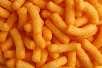 Photo of Tasty cheesy corn puffs as background, top view