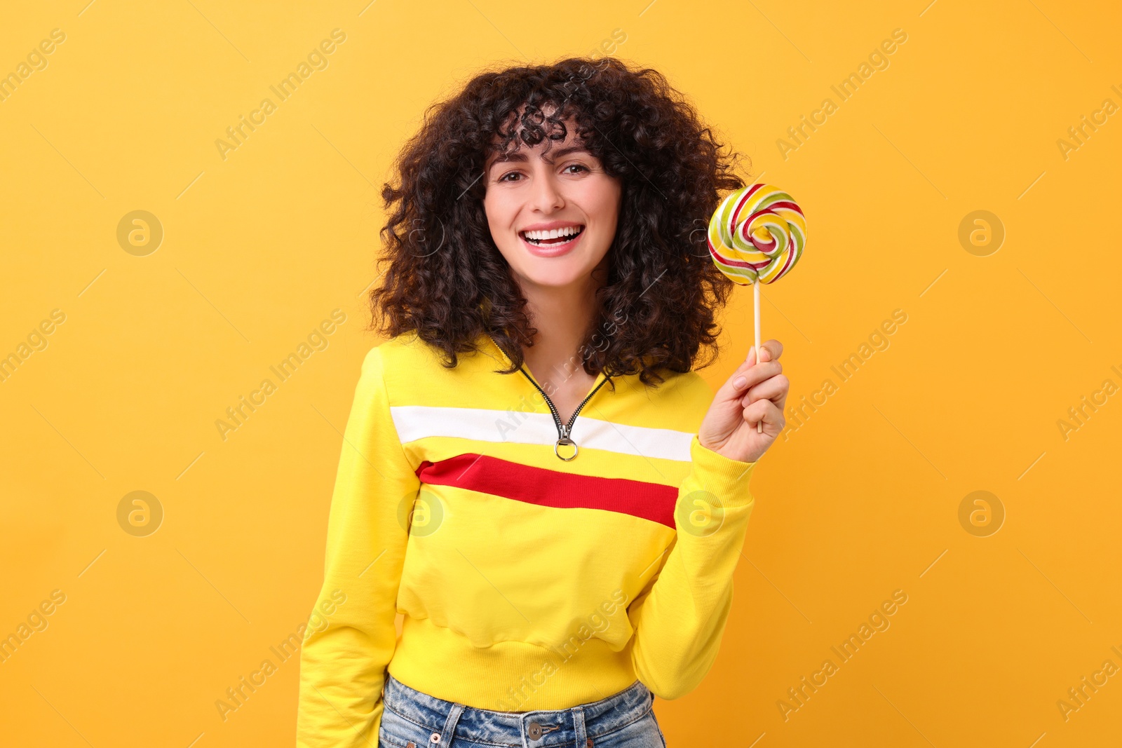 Photo of Beautiful woman with lollipop on yellow background