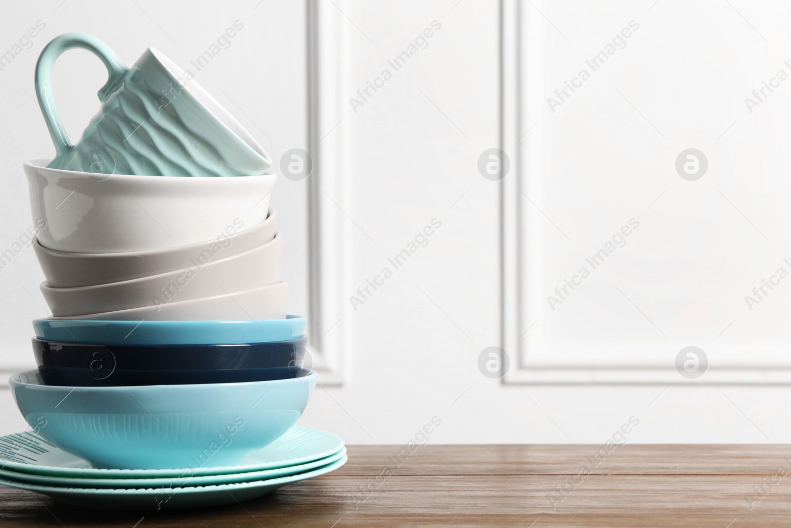 Photo of Beautiful ceramic dishware and cup on wooden table, space for text