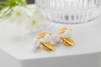 Beautiful earrings on white podium. Luxury jewelry
