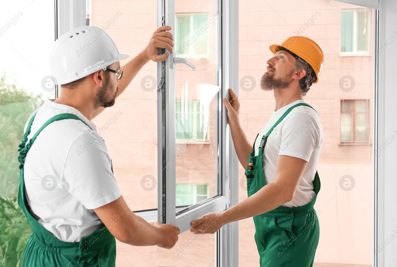 Photo of Construction workers installing new window in house