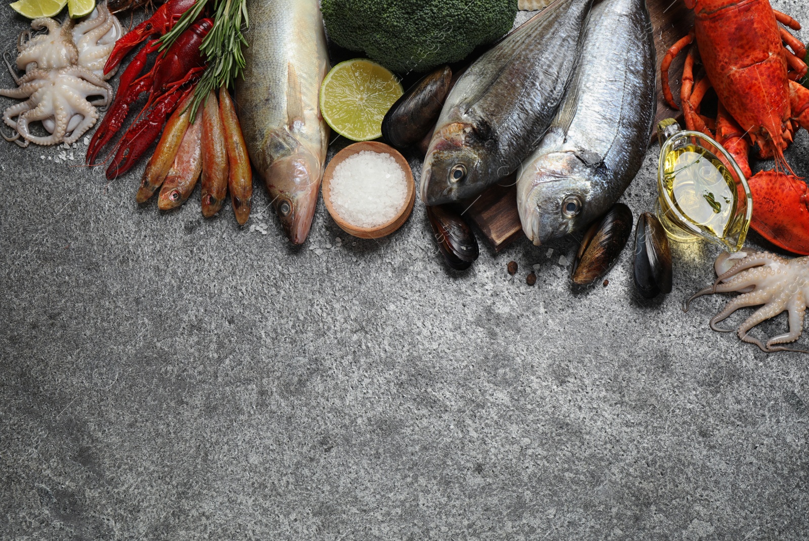 Photo of Fresh fish and different seafood on grey table, flat lay. Space for text