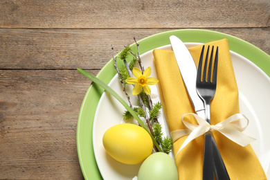 Festive Easter table setting with beautiful narcissus and painted eggs, top view