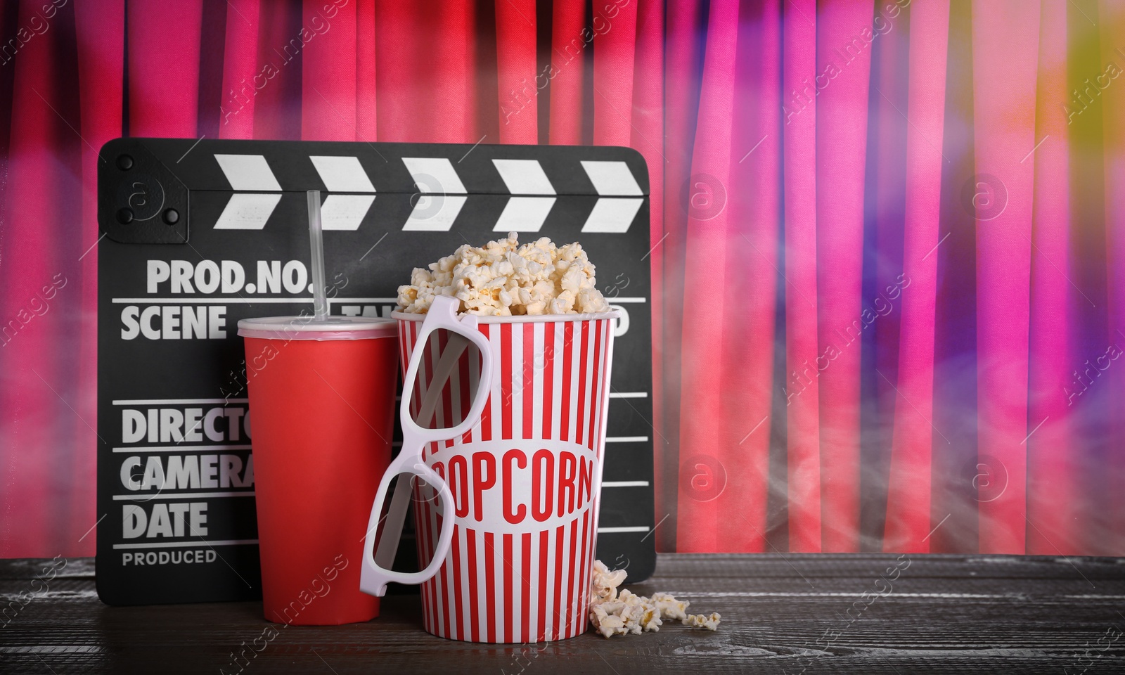 Image of Delicious popcorn, drink, 3D glasses and clapperboard on wooden table against closed red main curtain, space for text