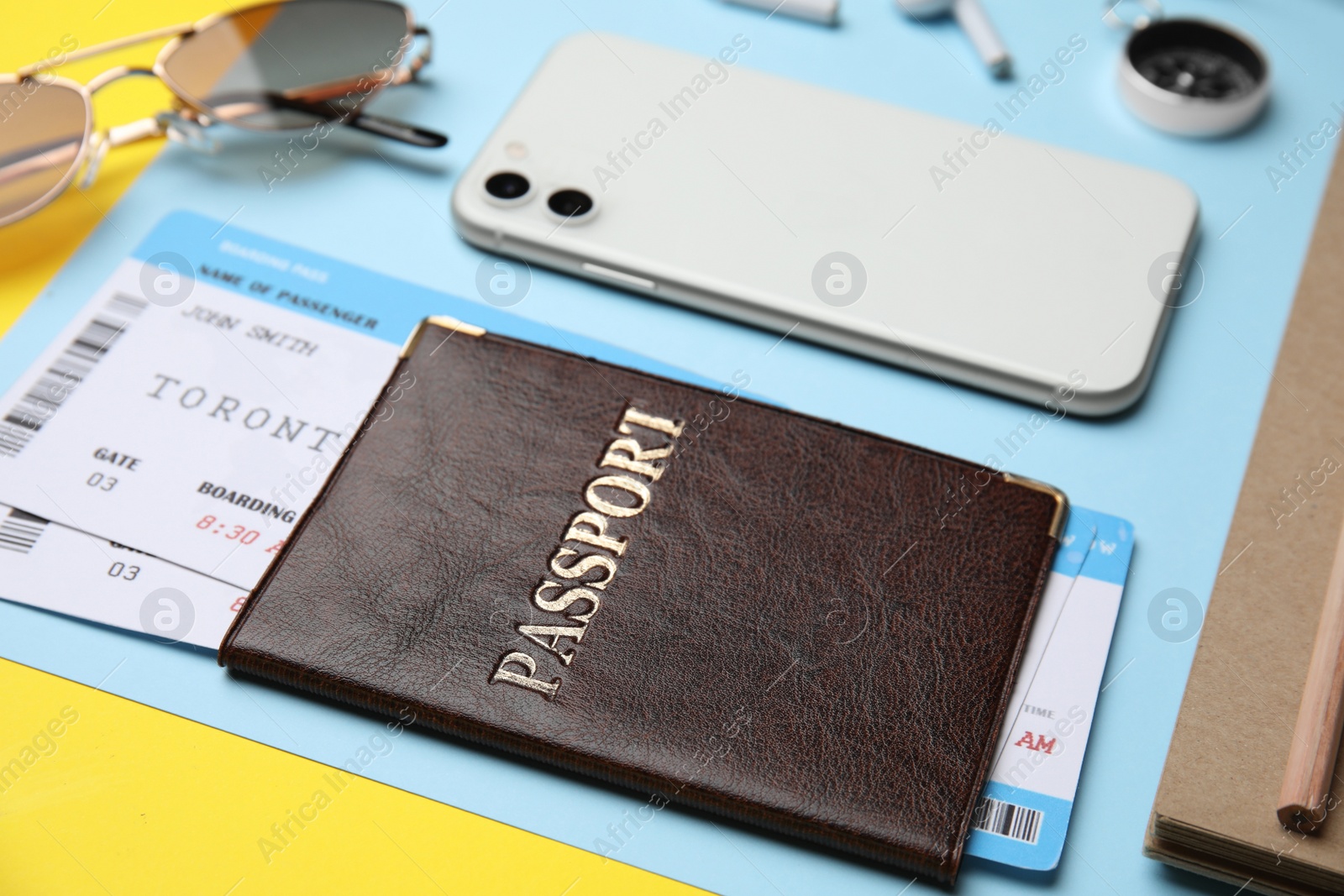 Photo of Passport with tickets near travel items on color background, closeup