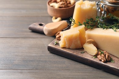 Photo of Delicious parmesan cheese served with honey, walnuts and thyme on wooden table, closeup. Space for text