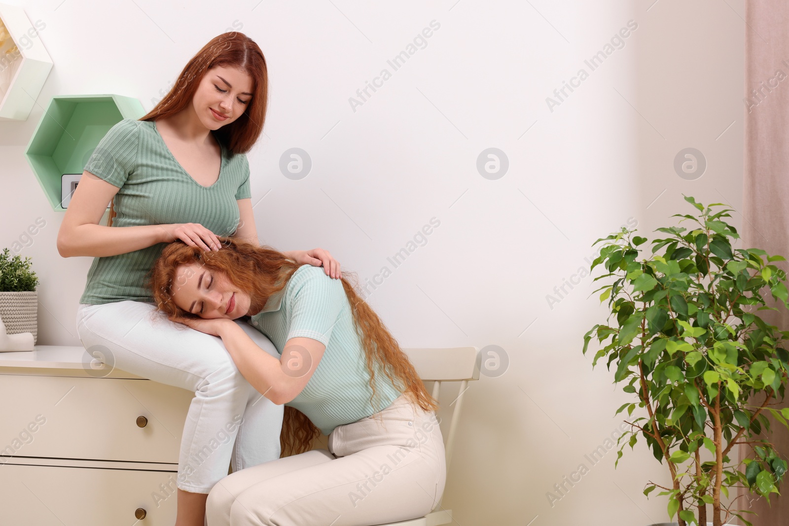 Photo of Portrait of beautiful young redhead sisters at home. Space for text