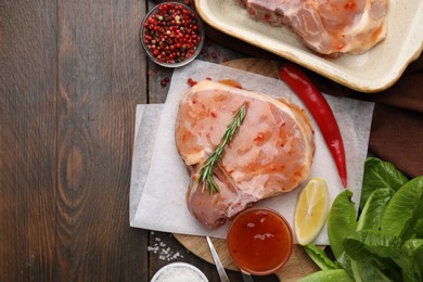 Photo of Flat lay composition with raw marinated meat, lemon, rosemary and spices on wooden table. Space for text