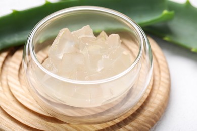 Photo of Aloe vera gel in bowl on white background, closeup