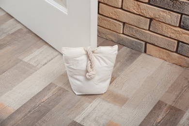 Photo of Stuffed bag holding wooden door at home