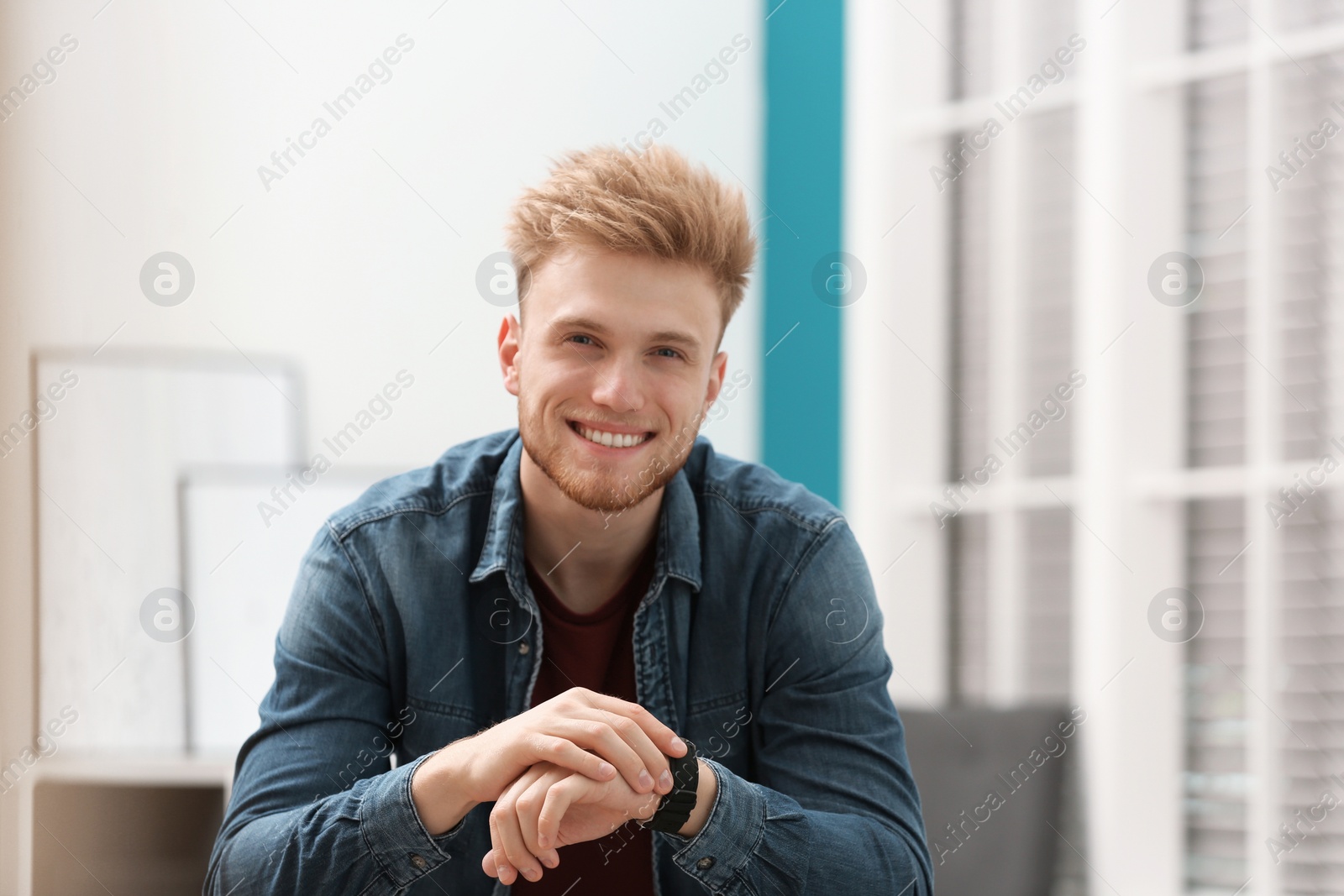 Photo of Portrait of handsome young man with wristwatch in room