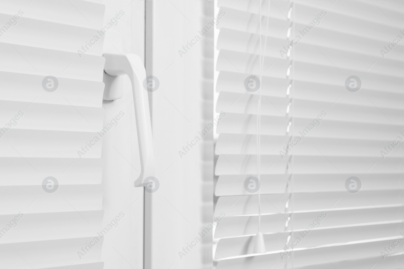 Photo of Window with closed white horizontal blinds indoors, closeup