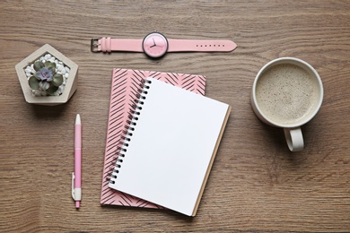 Flat lay composition with office stationery and cup of coffee on wooden table. Space for design