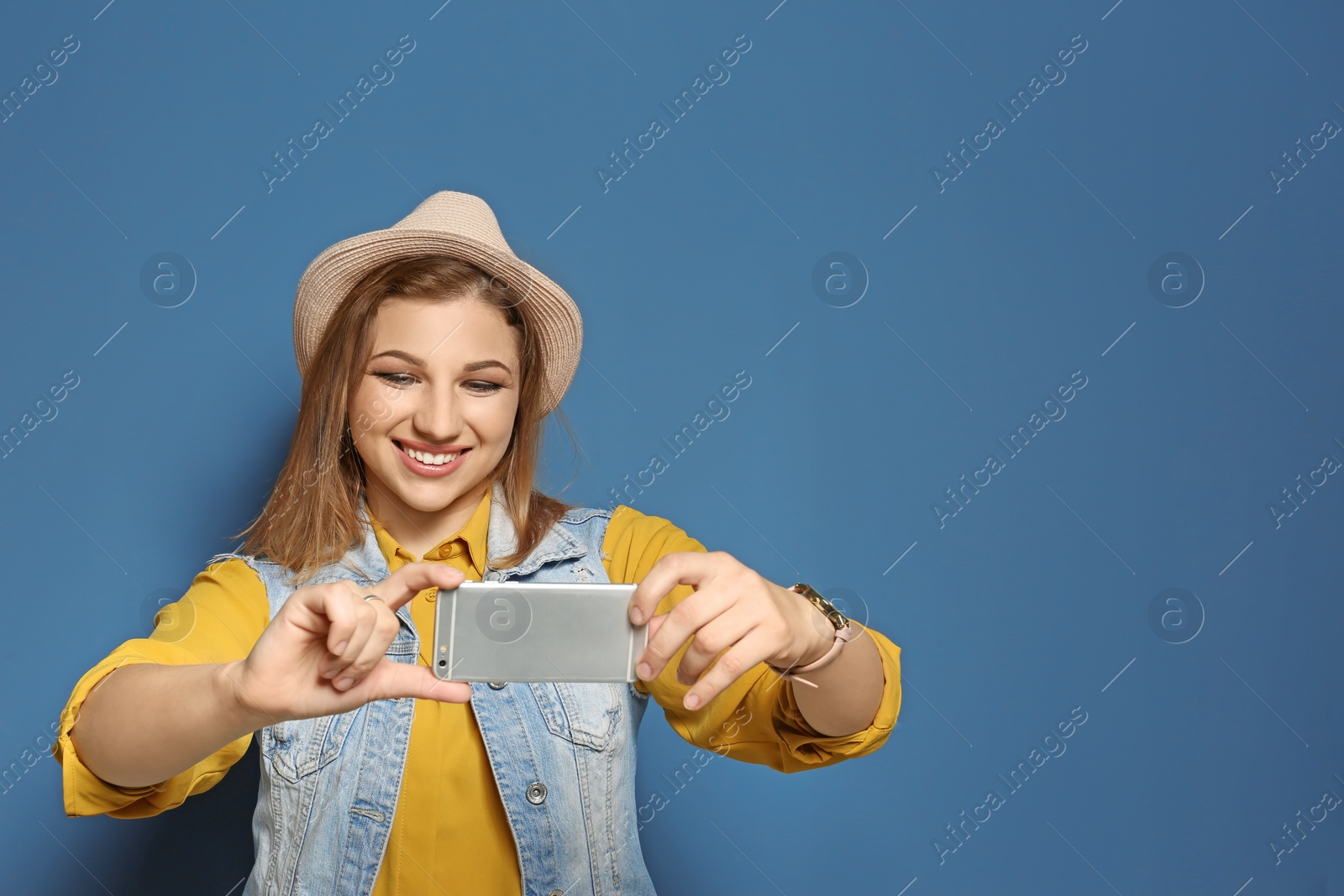 Photo of Attractive young woman taking selfie on color background