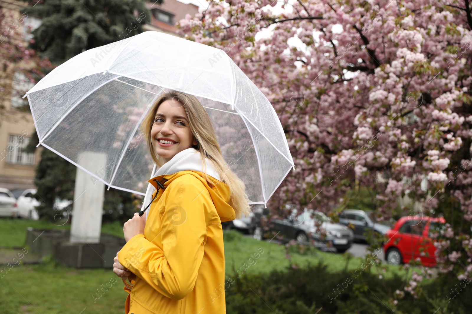 Photo of Young woman with umbrella in park on spring day