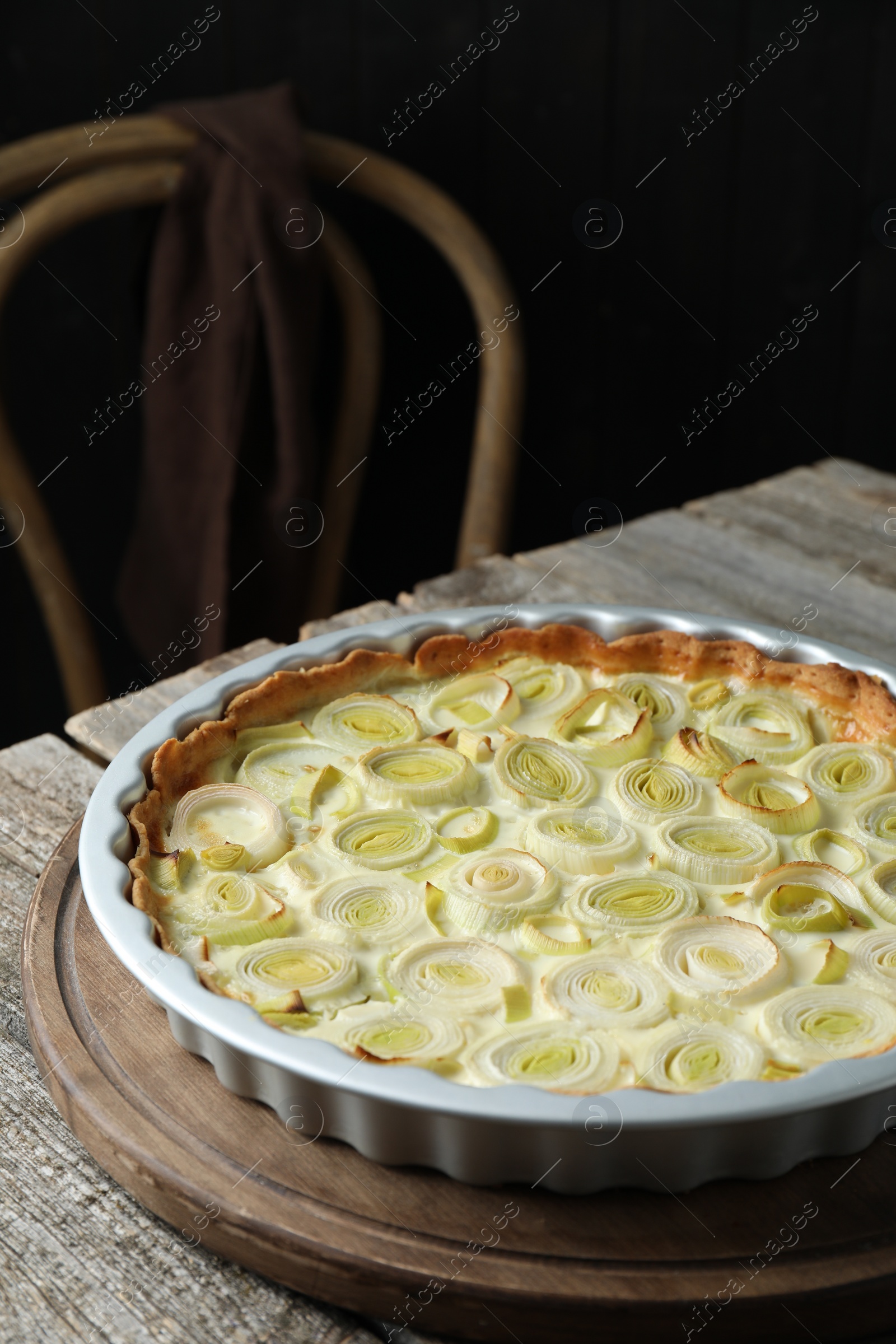 Photo of Freshly baked leek pie on old wooden table