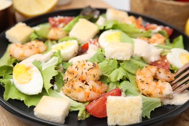 Photo of Delicious Caesar salad with shrimps on table, closeup