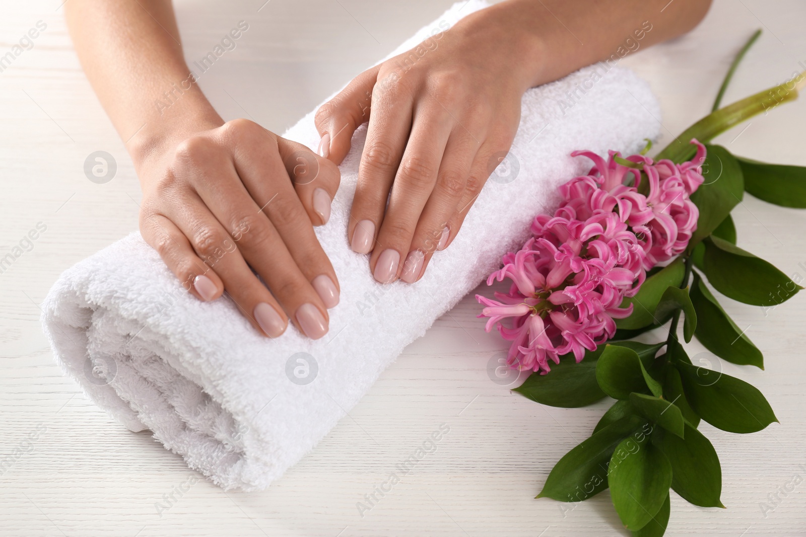 Photo of Closeup view of woman with beautiful hands at table. Spa treatment